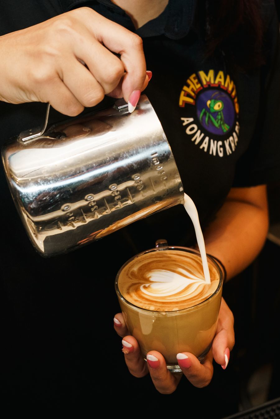 Barista pouring steamed milk to make latte art